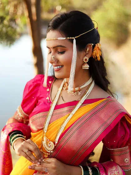 A close-up of the bride, focusing on her beautiful smile and the traditional mundavalya on her forehead.