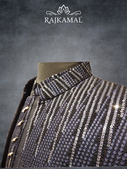 A close-up of the collar and shoulder of the navy blue striped jacket, revealing the texture of the sequin work.