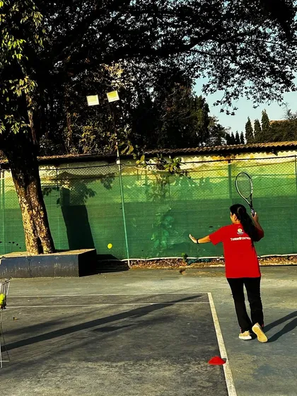 A player in our red team jersey practices her forehand during a drill, showing power and precision.