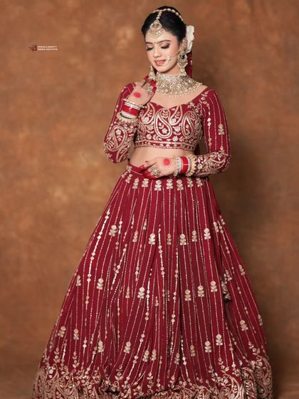 A full length view of this breathtaking bridal look. The hairstyle provides a clean and elegant frame for the face, ensuring the bride herself is the center of attention.