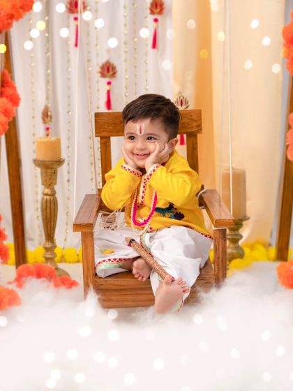A contemplative 'Little Kanha'. Even the quiet moments are beautiful, showcasing the intricate details of the costume and the dreamy, cloud-like set.