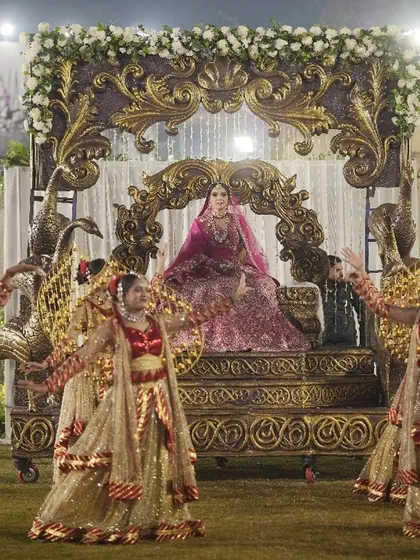I believe a bride's entrance should be nothing short of majestic. Here, I crafted a royal arrival on an ornate palanquin, surrounded by dancers and a path of ethereal smoke, making her first appearance as a bride truly unforgettable.