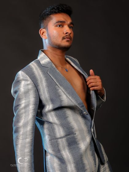 A profile shot that emphasizes the texture and pattern of the suit. The simple, dark background ensures the subject remains the focal point.
