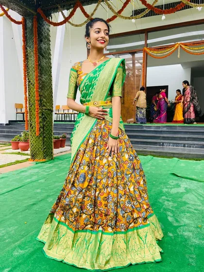 This is where tradition meets a bit of fun. I created this custom Kalamkari half saree, pairing the intricate printed skirt with a bright green blouse and a contrasting Banarasi georgette dupatta for a truly unique and festive langa voni.