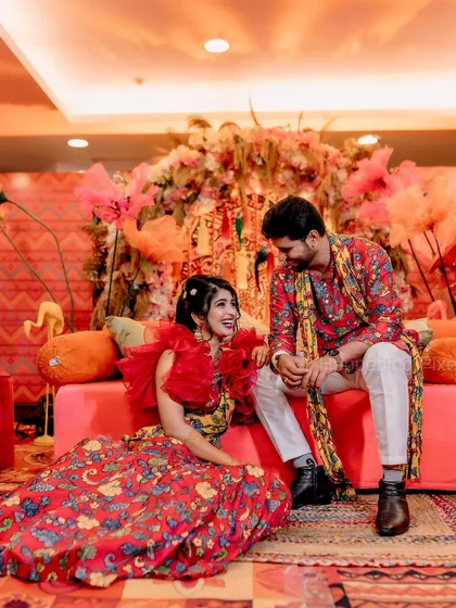 The couple seated against the vibrant Mehendi backdrop. We used a mix of traditional Indian patterns and modern floral arrangements to create this unique look.