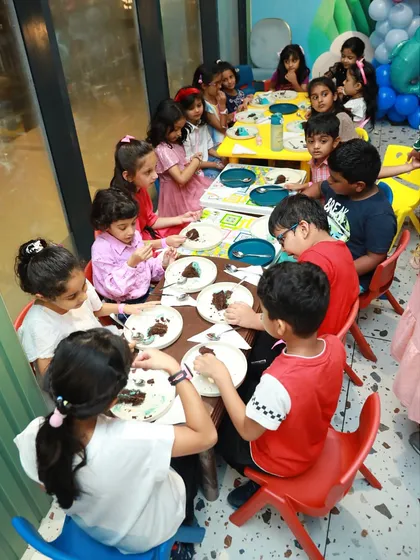 The best part of any party is sharing a meal with friends. Here, a group of children are gathered at our colorful tables, happily eating cake and snacks during an under the sea themed birthday celebration.