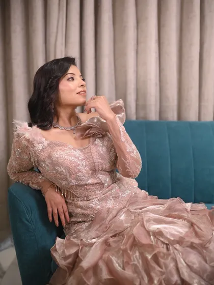 A close-up of this stunning ruffled gown. The intricate lace and dramatic shoulder detail make it a true work of art.