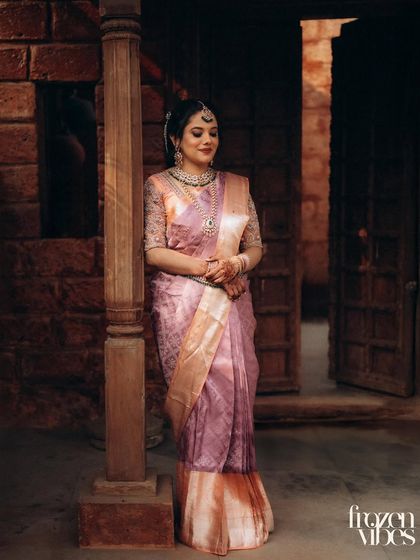 A full-length portrait of the bride in a heritage setting. The dramatic lighting and historic background add a sense of timelessness and grandeur.