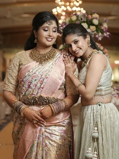 A sweet moment between the two sisters. Their makeup is designed to look beautiful in candid, emotional photos.