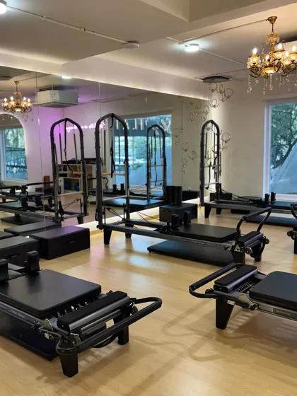Another view of the main studio, showing the full set of reformers and Cadillac machines ready for a full-body workout.