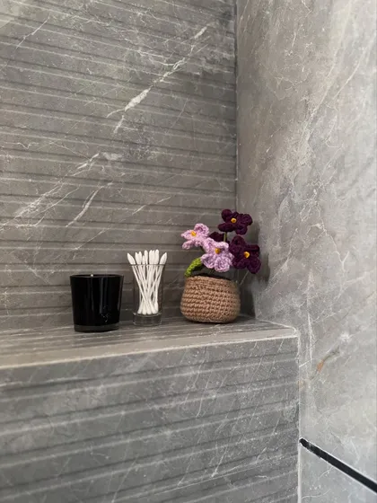 Even the smallest corners deserve a touch of beauty. Our mini potted flower is shown here adding a pop of color to a bathroom shelf.