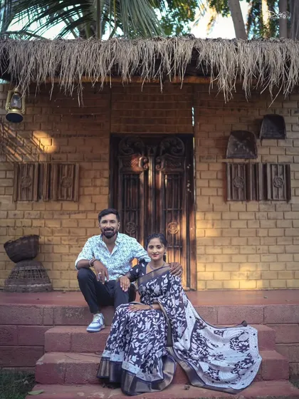 A relaxed portrait on the steps of a rustic, brick-and-thatch house. This location offers a unique, earthy vibe for a traditional pre-wedding shoot.