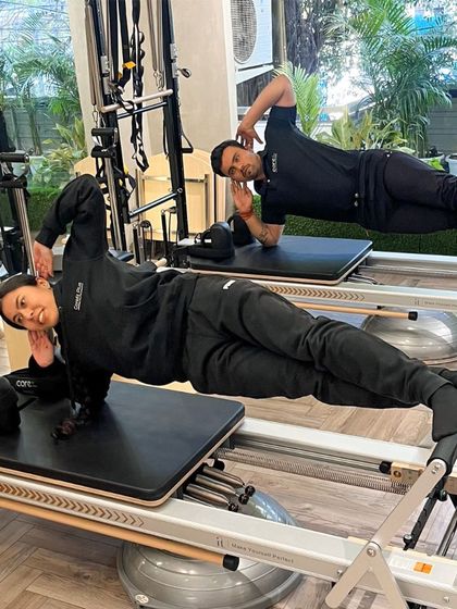 Mirror, mirror on the wall. Our trainers rock a synchronized side plank on the Reformer, showcasing the strength and control we teach.