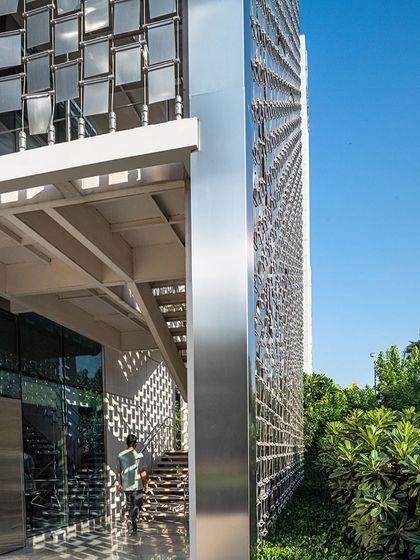 A view from the base of the fire staircase, looking up at the intricate steel screen against the sky, showcasing the engineering and fabrication complexity of this unique façade element.