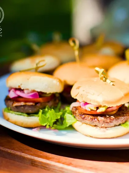 Our mini burgers are a crowd-pleasing favorite. These perfectly crafted sliders, served on a clean white plate, are an example of how we present even casual foods with a touch of gourmet elegance.