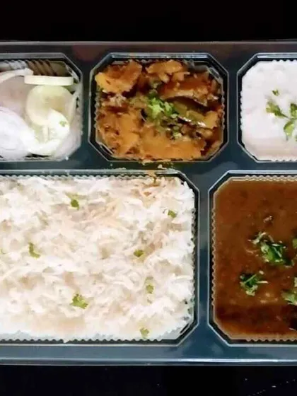This is what our standard daily tiffin looks like. It's a complete, balanced meal with dal, sabzi, rice, and salad, all hygienically packed and ready to eat. We ensure good quantity and quality in every box.