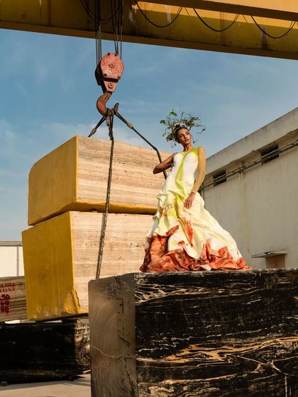 Another perspective from the conceptual marble factory shoot, highlighting the scale of the raw materials. The model is positioned atop massive marble blocks, creating a powerful image of strength and elegance.