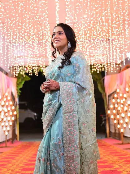 This guest looks stunning under the fairy lights in her beautiful blue saree. The makeup is designed to catch the light perfectly.