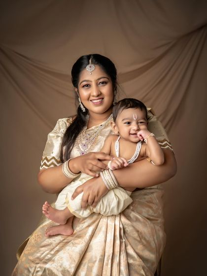 A mother and her little Krishna, sharing a sweet moment in their traditional outfits.