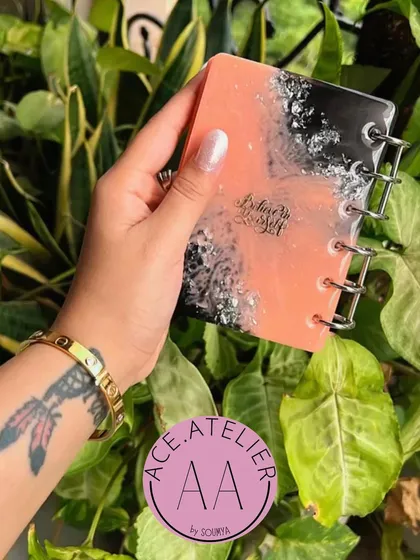 A personalized resin diary with a beautiful peach and black marble effect. The cover is customized with a name and a motivational quote.
