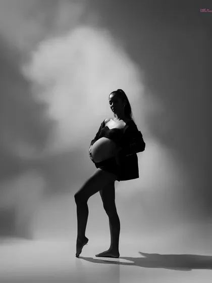 A bold, black and white silhouette of a mother-to-be in a dancer's pose, celebrating her strength and grace.