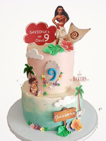 A Moana-themed cake for Saviona's 9th birthday. This no-fondant, two-tier cake captures the tropical, adventurous spirit of the movie, with Moana and other island details.