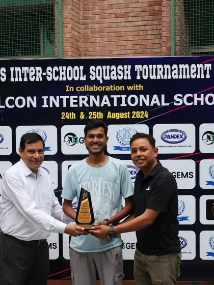 Awarding a trophy to a student player for his excellent performance during the inter-school championship.