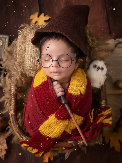 The chosen one. A perfectly posed newborn Harry Potter, complete with his wand, glasses, and a tiny Hedwig.