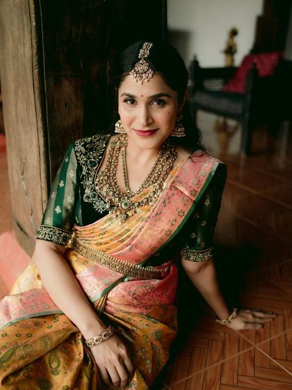 A moment of quiet contemplation. The intricate details of the saree and the heavy temple jewelry create a look that is both regal and deeply traditional.