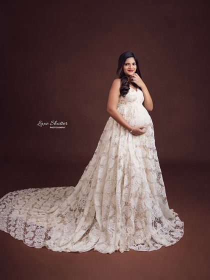A classic pose that radiates happiness and style. The full train of the lace gown creates a beautiful, sweeping line, making for a truly elegant photograph.