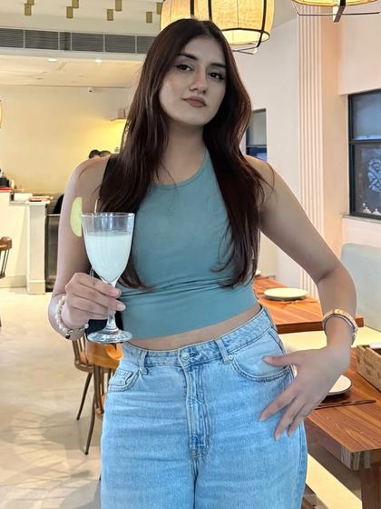 Enjoying a matcha day in a casual and cute outfit: a sage green halter top and light-wash jeans.