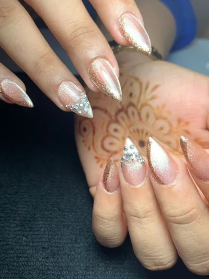A close-up of stiletto extensions with a cat-eye base and diamond-like crystal tips. This is a perfect look for an engagement or cocktail party.