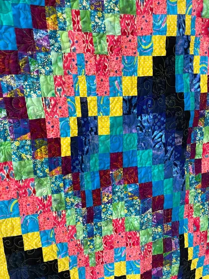A close-up of the intricate patchwork in the bright Bargello quilt.