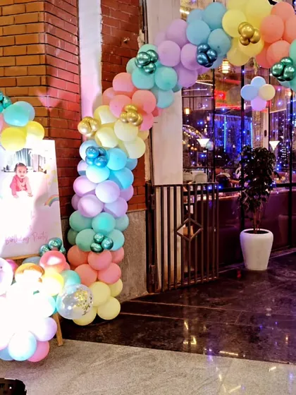 The entrance decoration for the Cocomelon party, featuring a pastel-colored balloon arch.