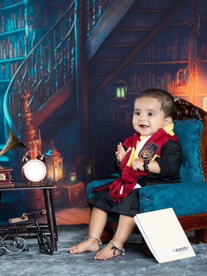 A happy little wizard from Gryffindor, sitting in a magical library. The perfect photoshoot for any Potterhead family.