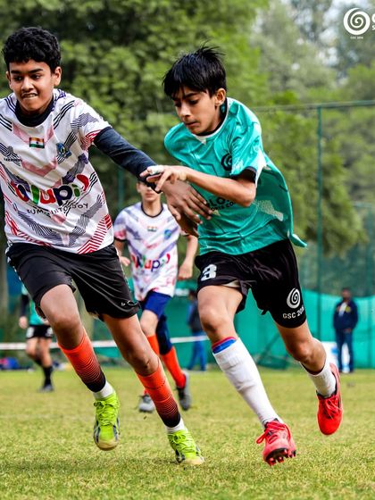 A fast-paced moment as a player in a green jersey tries to outrun a defender from the opposing team.