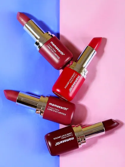 A graphic arrangement of four Mamaearth lipsticks on a split-color background. This top-down shot is ideal for showcasing a range of shades for social media or catalog use.