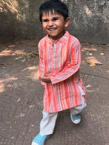 A duplicate of ID 7, this photo captures the pure joy of a child comfortable in his festive wear. The striped pink cotton kurta is a perfect example of our soft, breathable fashion.