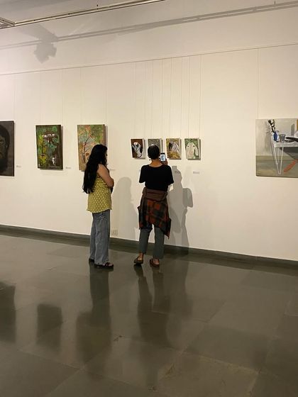 Visitors admiring the paintings on display at 'ME, AMMA, WE'.