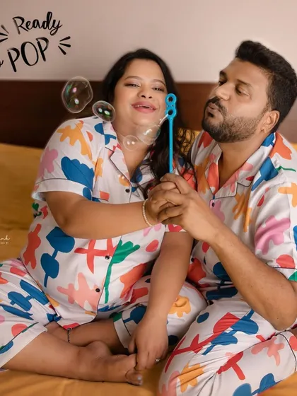 Ready to pop! This fun photo with bubbles adds a touch of whimsy to their pajama-themed maternity shoot, perfectly capturing their playful personalities.