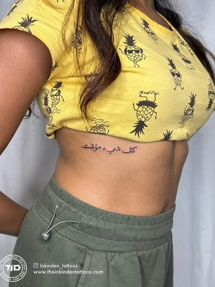 An elegant Arabic script tattoo on the rib cage that reads "Everything is temporary." The placement and delicate lettering make this a personal and profound reminder to live in the moment.