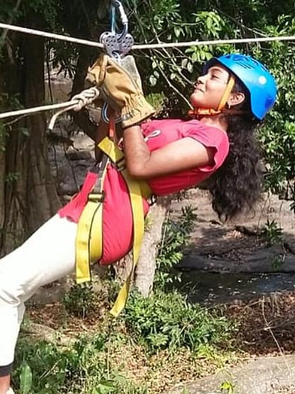 A participant focuses as she glides along the zipline, building confidence and overcoming fear.
