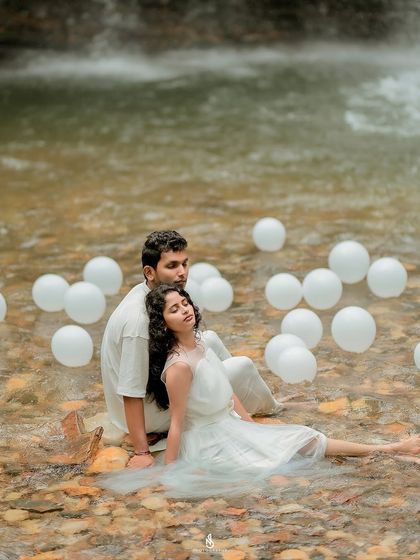 A peaceful pose, relaxing together in the shallow water. The white dress flowing in the current adds a beautiful, ethereal touch.