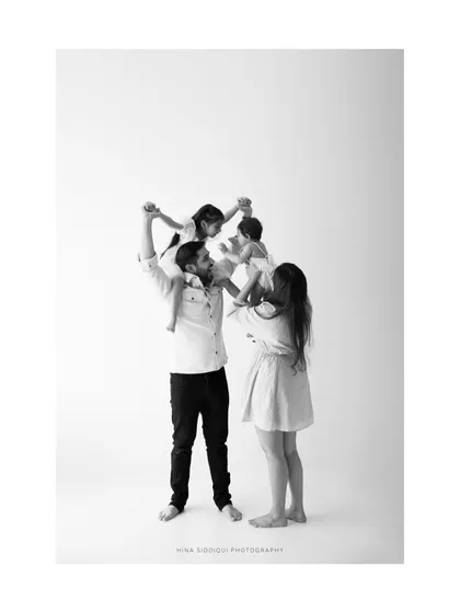 The strength and joy of a family unit, all together. This full family portrait shows the playful side of parenting and the happiness of being together.
