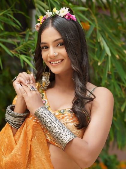 A happy and playful portrait of the Haldi bride, showing off her oxidized silver jewelry and bright smile.