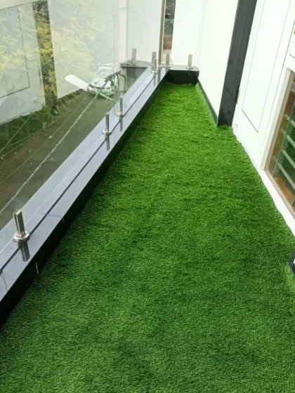 Even narrow balconies can be greatly improved with artificial turf. This installation covers the entire length of the balcony, providing a soft, clean surface that's pleasant to walk on and visually appealing.