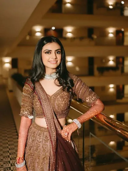 This bride opted for a sophisticated bronze and maroon lehenga for her sangeet. The makeup is warm and glowing, with softly defined eyes and a neutral lip to complement the rich tones of her outfit.