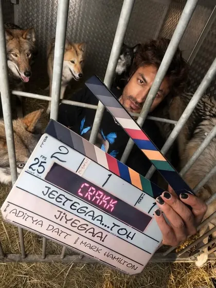 Vidyut Jammwal with the clapperboard in a cage with wolves for a thrilling scene in "Crakk". It was a unique challenge to design a costume that worked for this intense sequence.