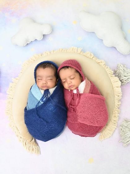 Dreaming on a rainbow. These two little ones are swaddled and sleeping together under a pastel rainbow, symbolizing the joy and hope they bring.
