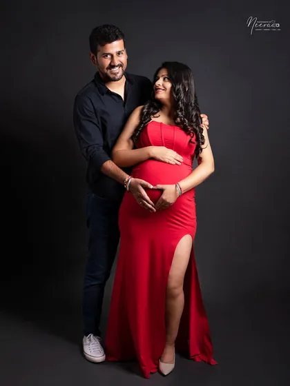 Another sweet heart hands pose, showing the love that surrounds this baby. The couple's happy expressions and connected pose make this a truly heartwarming image.